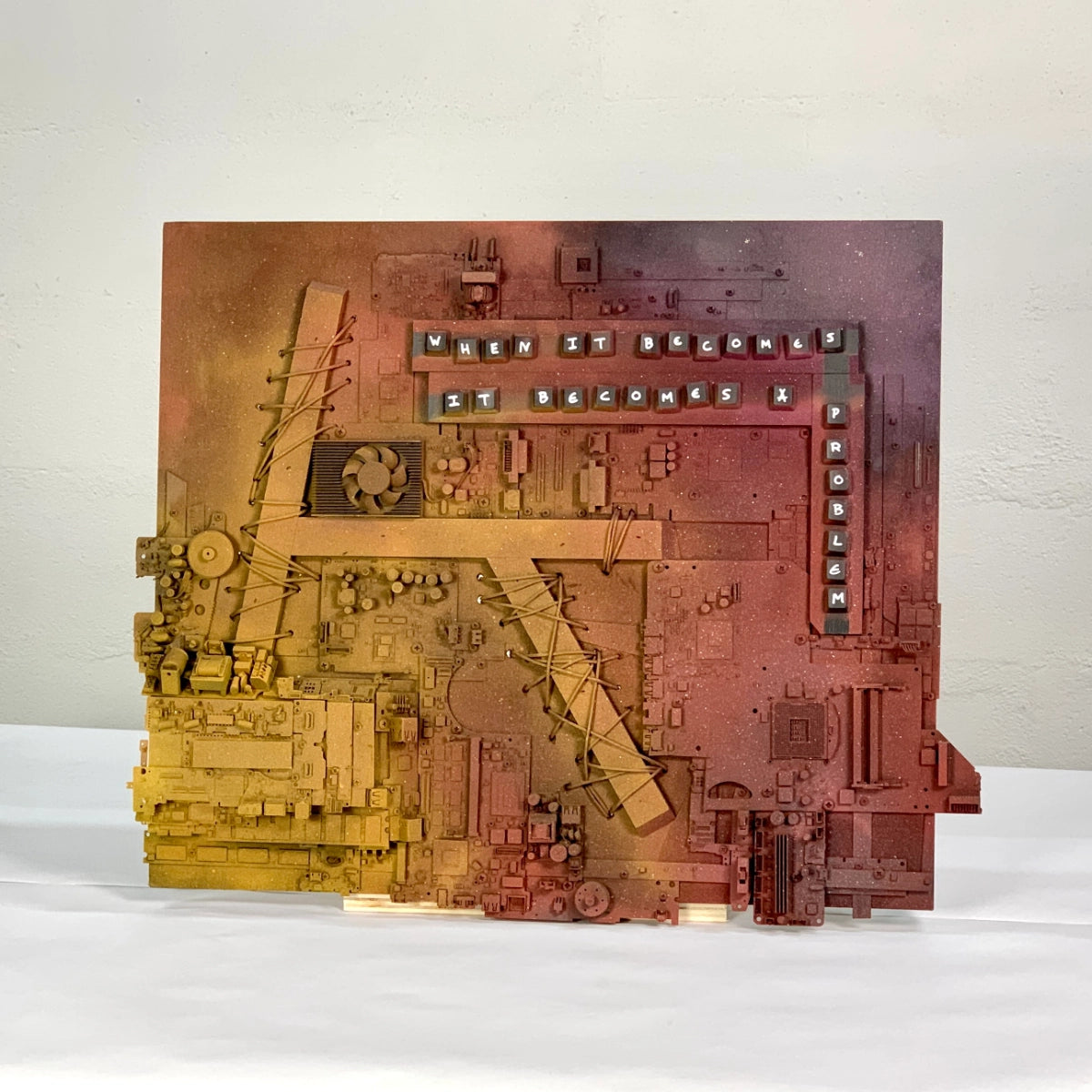 Mixed-media artwork combining electronic components, text and painted surfaces.